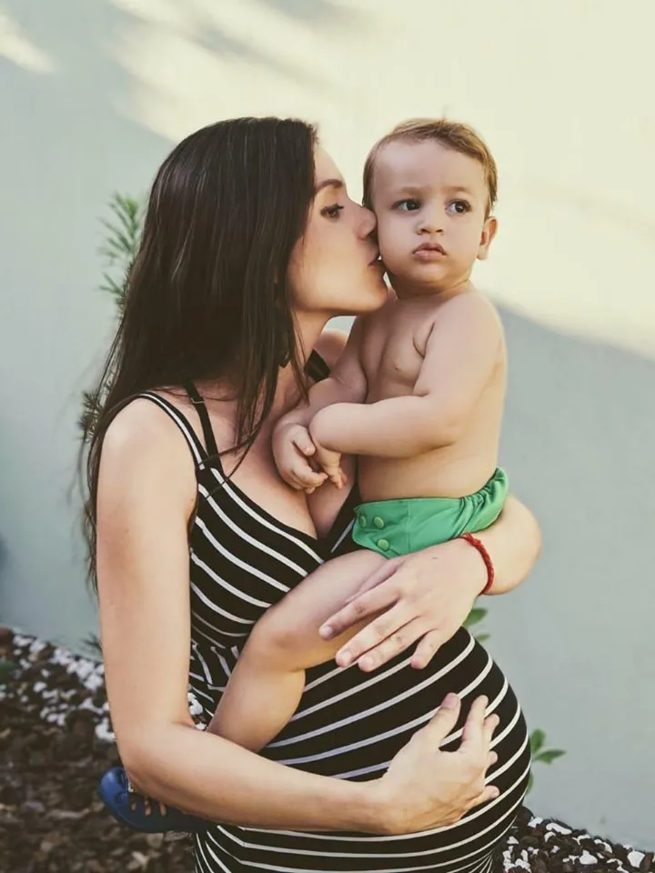 O que esperar com a chegada do segundo filho? mãe grávida segurando um bebê