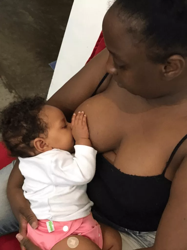 Mulher segurando um bebê durante a amamentação.