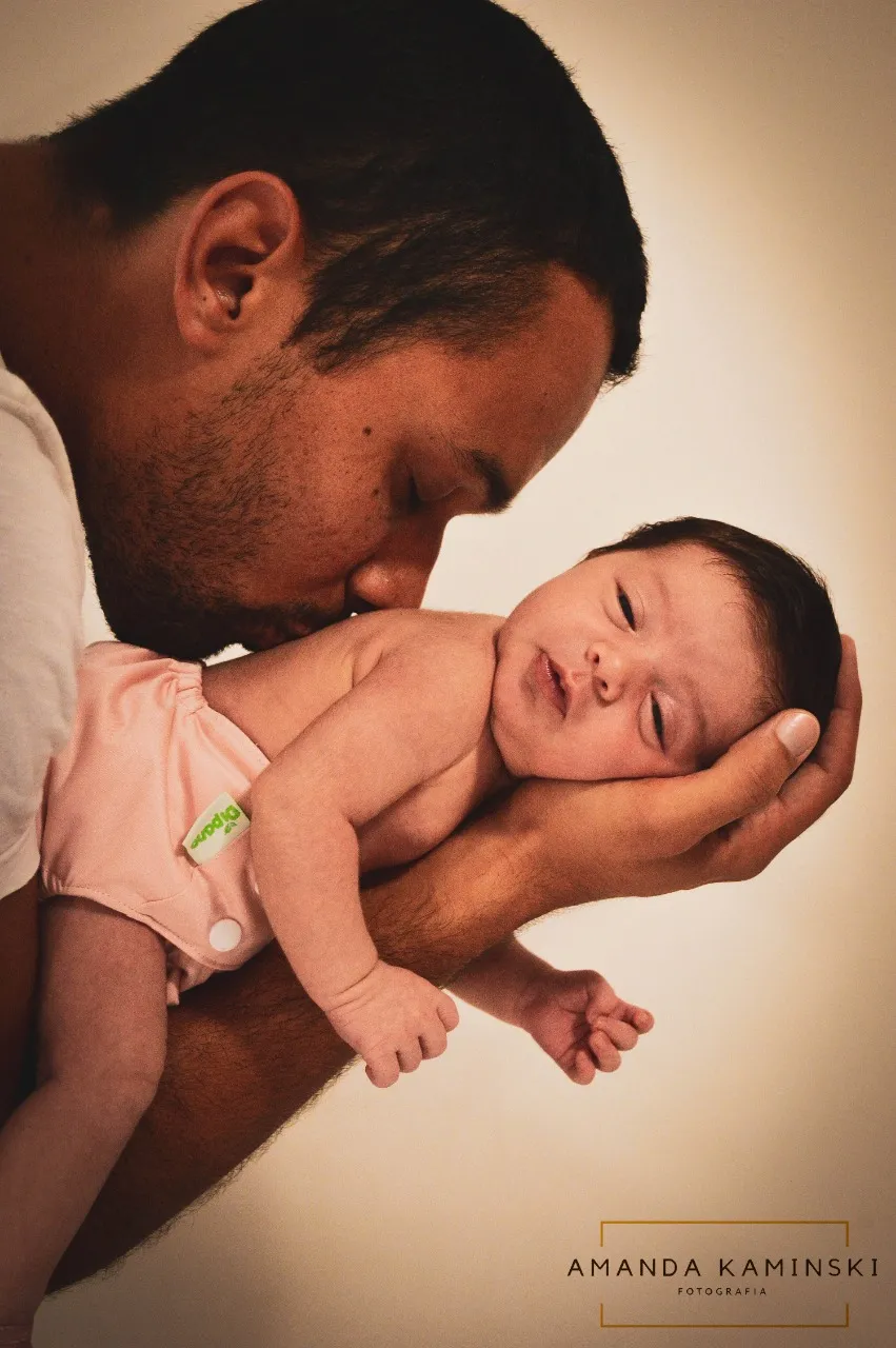 4. Dê sempre muito amor e carinho pai segurando os filhos no braço e beijando as costas