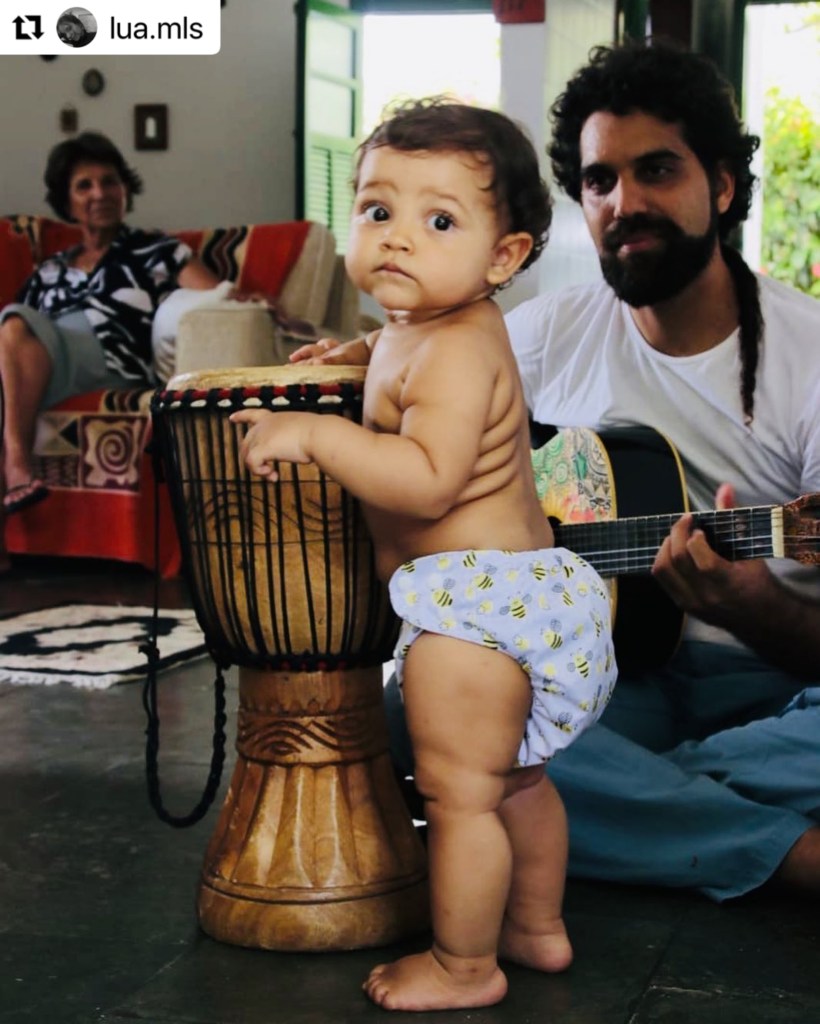 Criança em pé tocando tambom