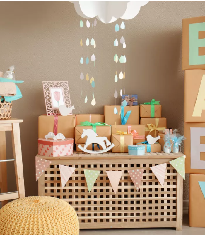 Mesa de chá de bebê decorada com quadro, caixas de papelão, caixas de madeira e escultura de cavalo.