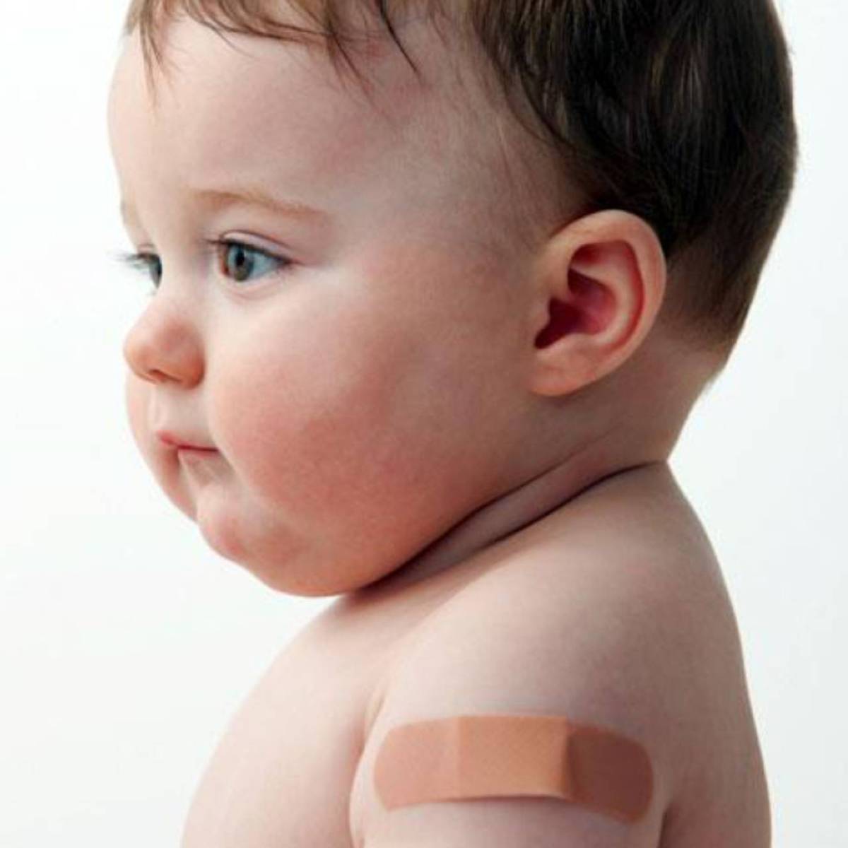 Bebê sorrindo com um band-aid no braço.